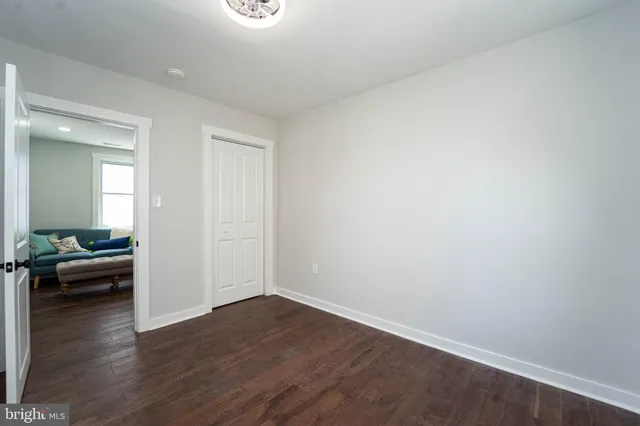 an empty room with wooden floor and couches