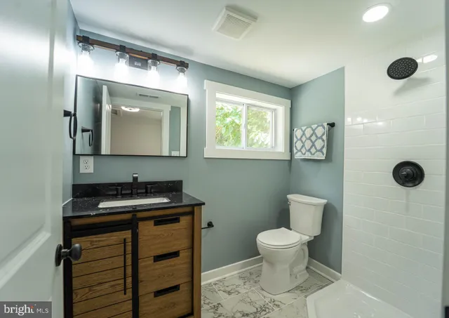 a bathroom with a toilet sink and mirror