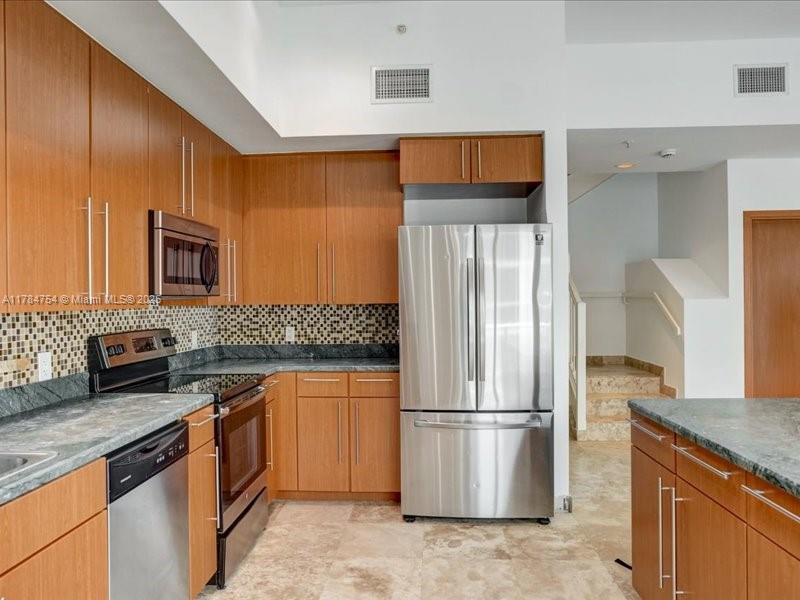 9499 Collins Avenue, Unit PH03 Surfside, FL 33154 - Photo 12 of 82 a kitchen with stainless steel appliances granite countertop a refrigerator and a sink