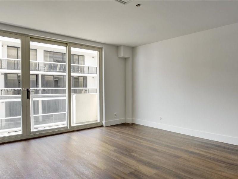 9499 Collins Avenue, Unit PH03 Surfside, FL 33154 - Photo 18 of 82 an empty room with wooden floor and windows