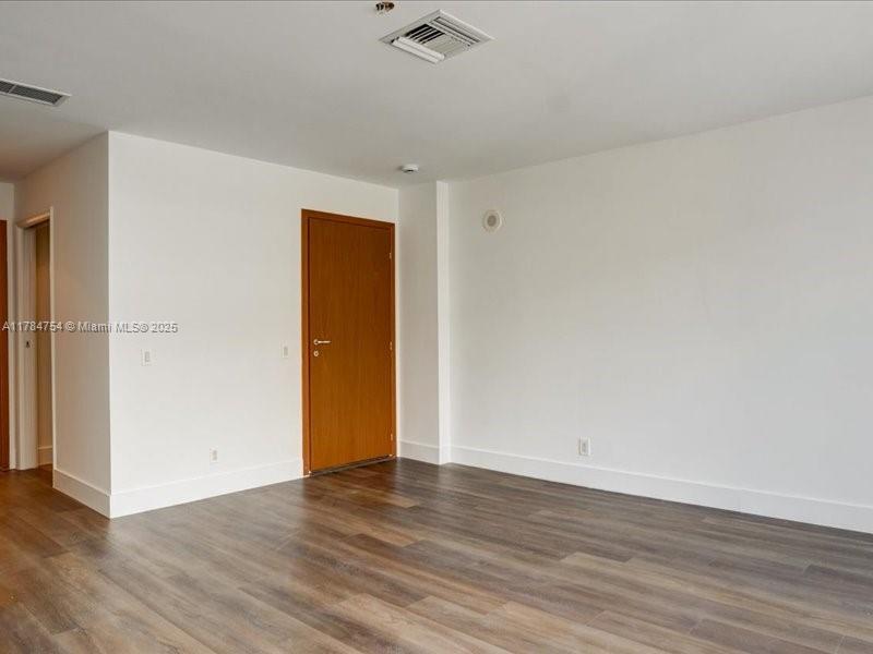 9499 Collins Avenue, Unit PH03 Surfside, FL 33154 - Photo 20 of 82 a view of an empty room with wooden floor and a window