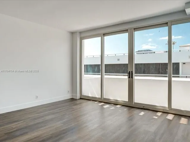 a view of a room with wooden floor and windows