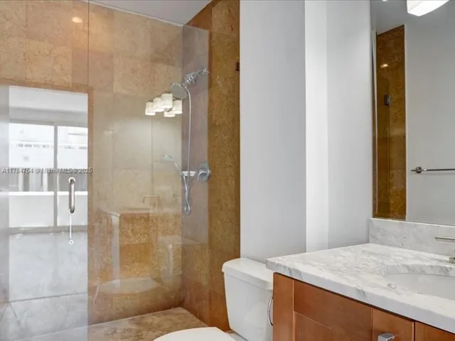 a bathroom with a sink a toilet and a large mirror