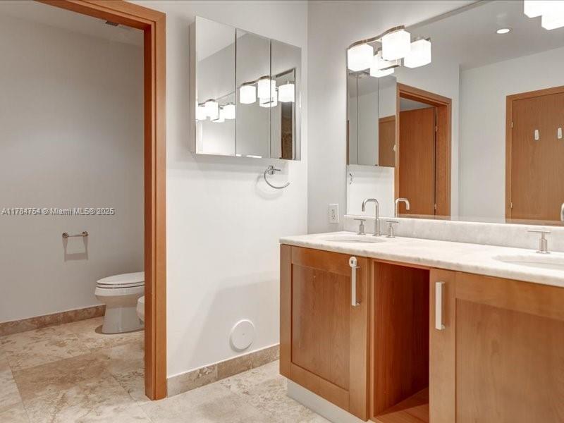 9499 Collins Avenue, Unit PH03 Surfside, FL 33154 - Photo 44 of 82 a bathroom with a sink a toilet and a large mirror