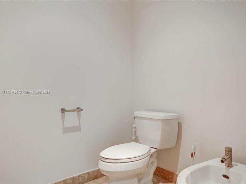 9499 Collins Avenue, Unit PH03 Surfside, FL 33154 - Photo 45 of 82 a white toilet sitting next to a bathroom sink