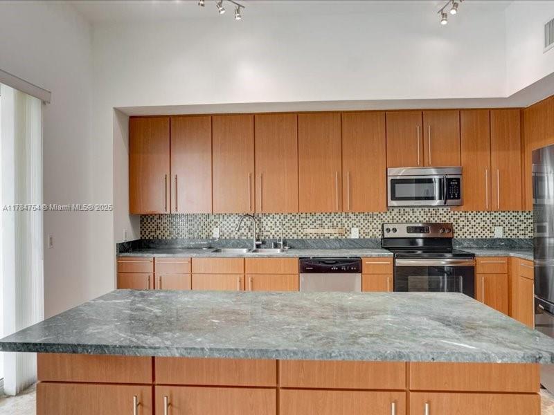 9499 Collins Avenue, Unit PH03 Surfside, FL 33154 - Photo 10 of 82 a kitchen with stainless steel appliances granite countertop a sink stove and microwave