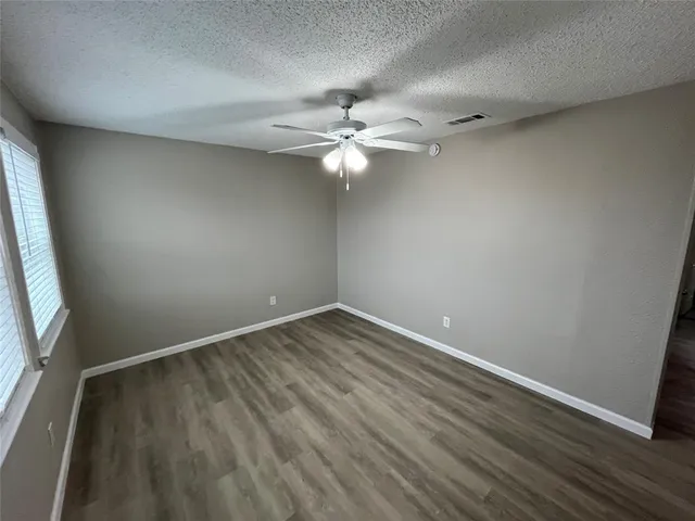 an empty room with a window and a fan