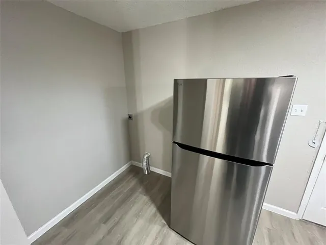 a view of a refrigerator in kitchen and wooden floor