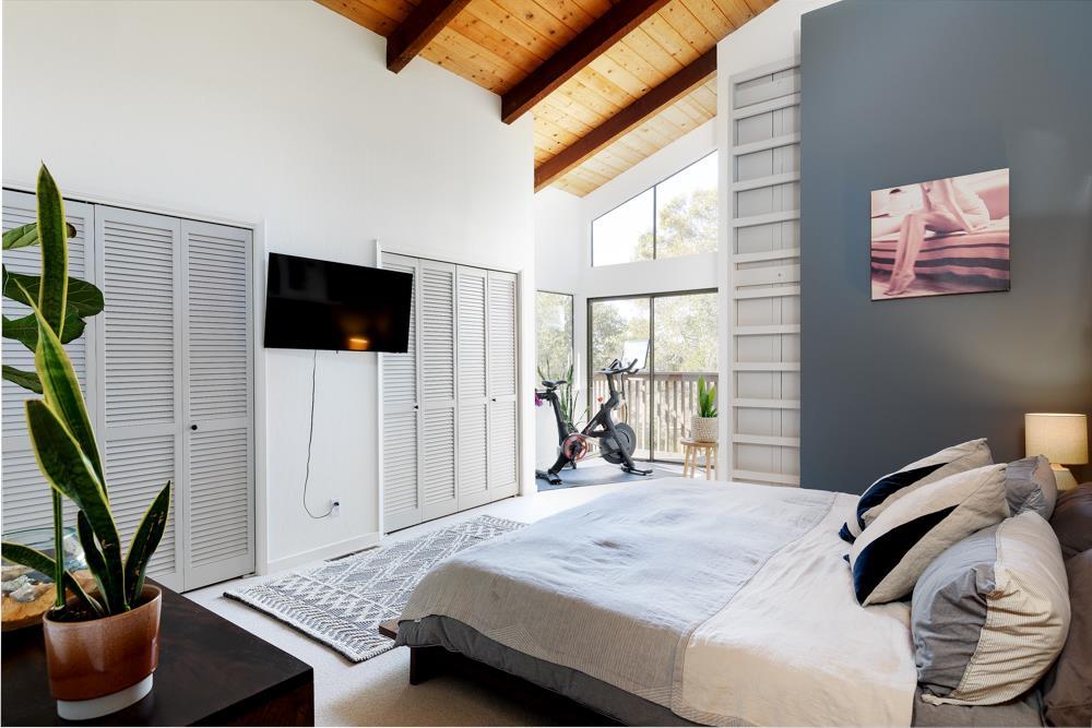 390 Brooktree Ranch Road Aptos, CA 95003 - Photo 17 of 31 a bedroom with a bed a large window and the flat screen tv