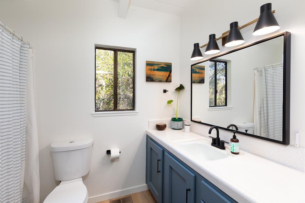 390 Brooktree Ranch Road Aptos, CA 95003 - Photo 23 of 31 a bathroom with a toilet a sink a mirror and window