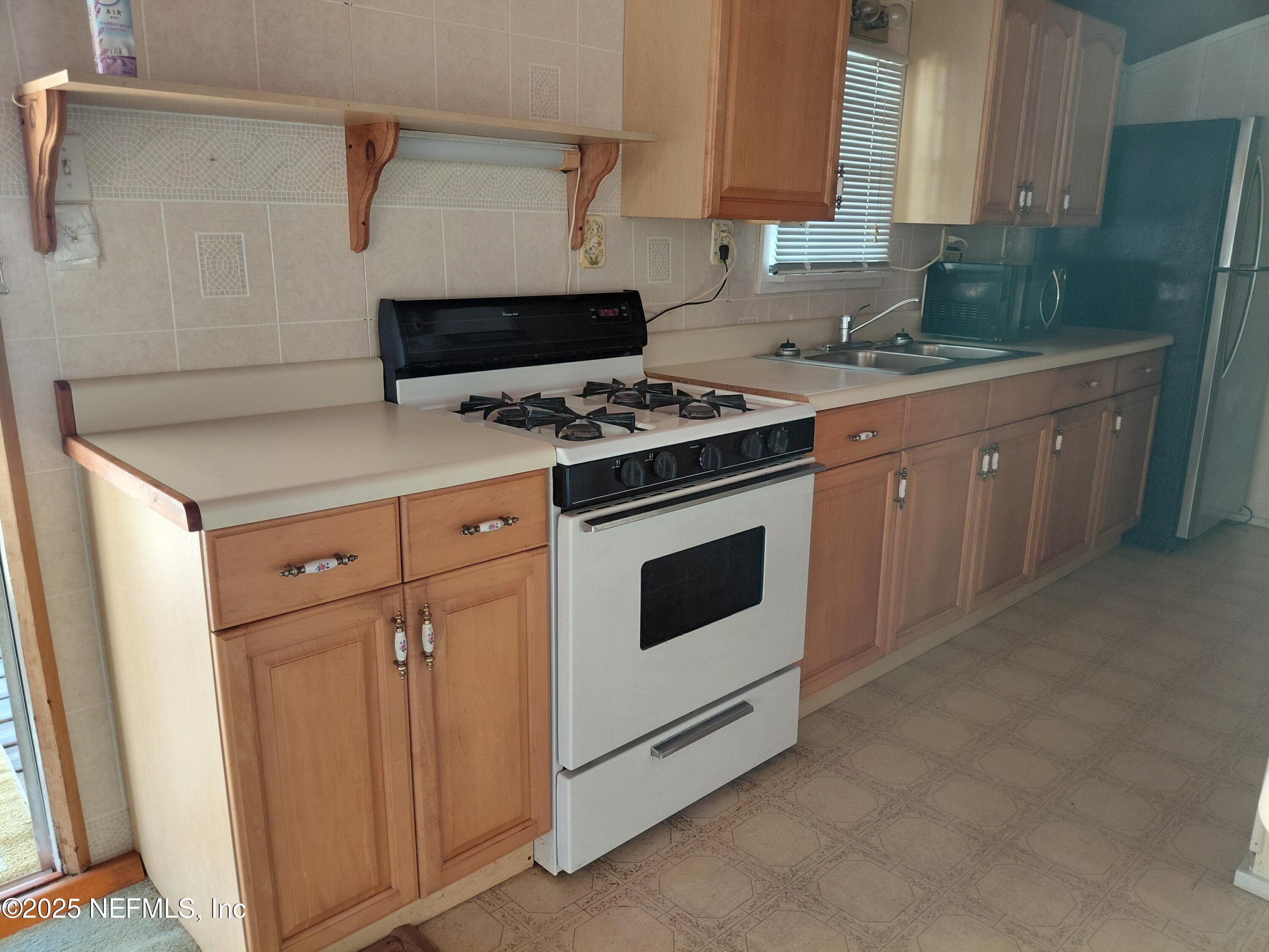 15690 Sears Road Jacksonville, FL 32218 - Photo 28 of 39 a white stove top oven sitting inside of a kitchen