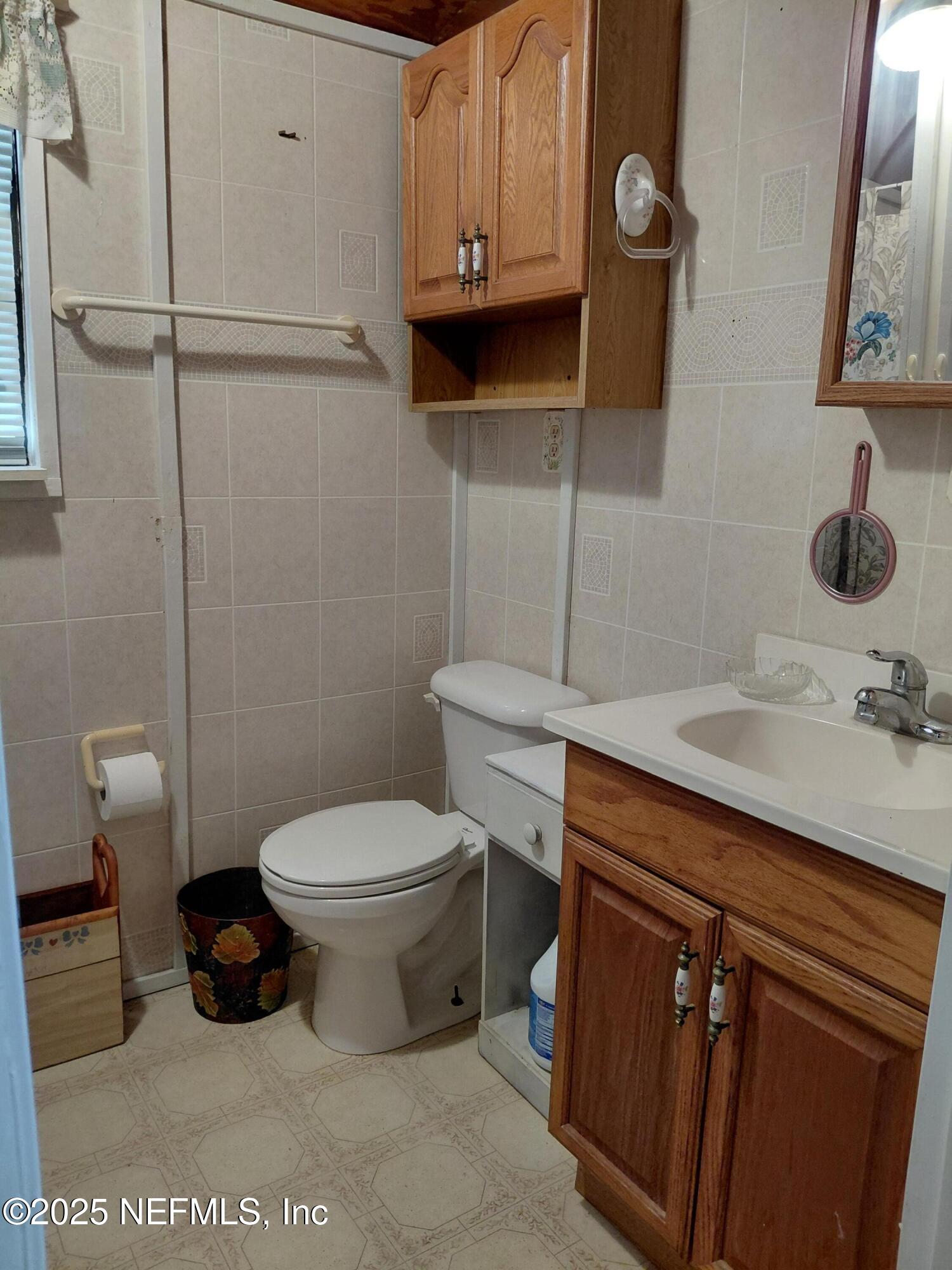 15690 Sears Road Jacksonville, FL 32218 - Photo 30 of 39 a bathroom with a toilet a sink and mirror