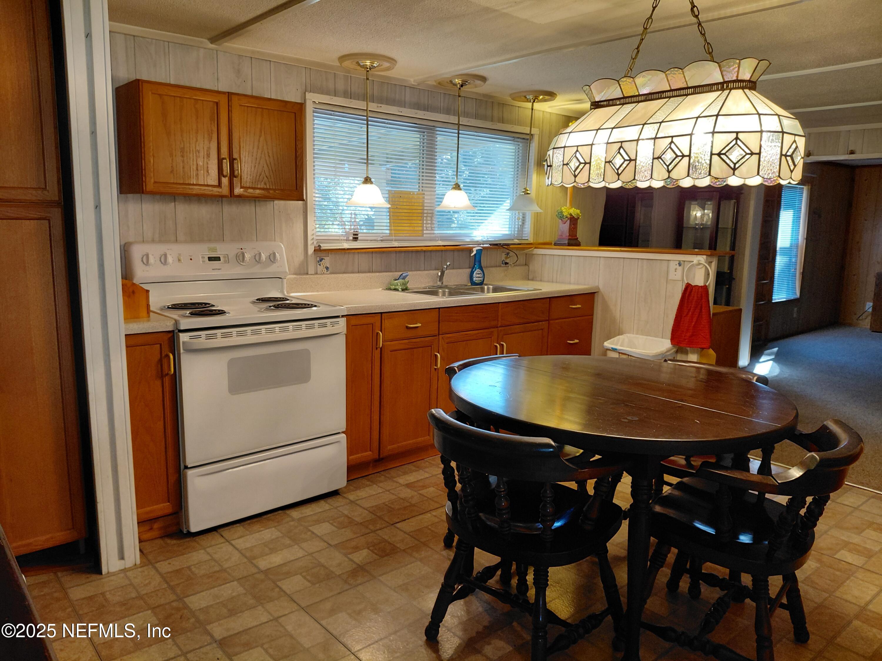 15690 Sears Road Jacksonville, FL 32218 - Photo 7 of 39 a kitchen with a dining table and chairs