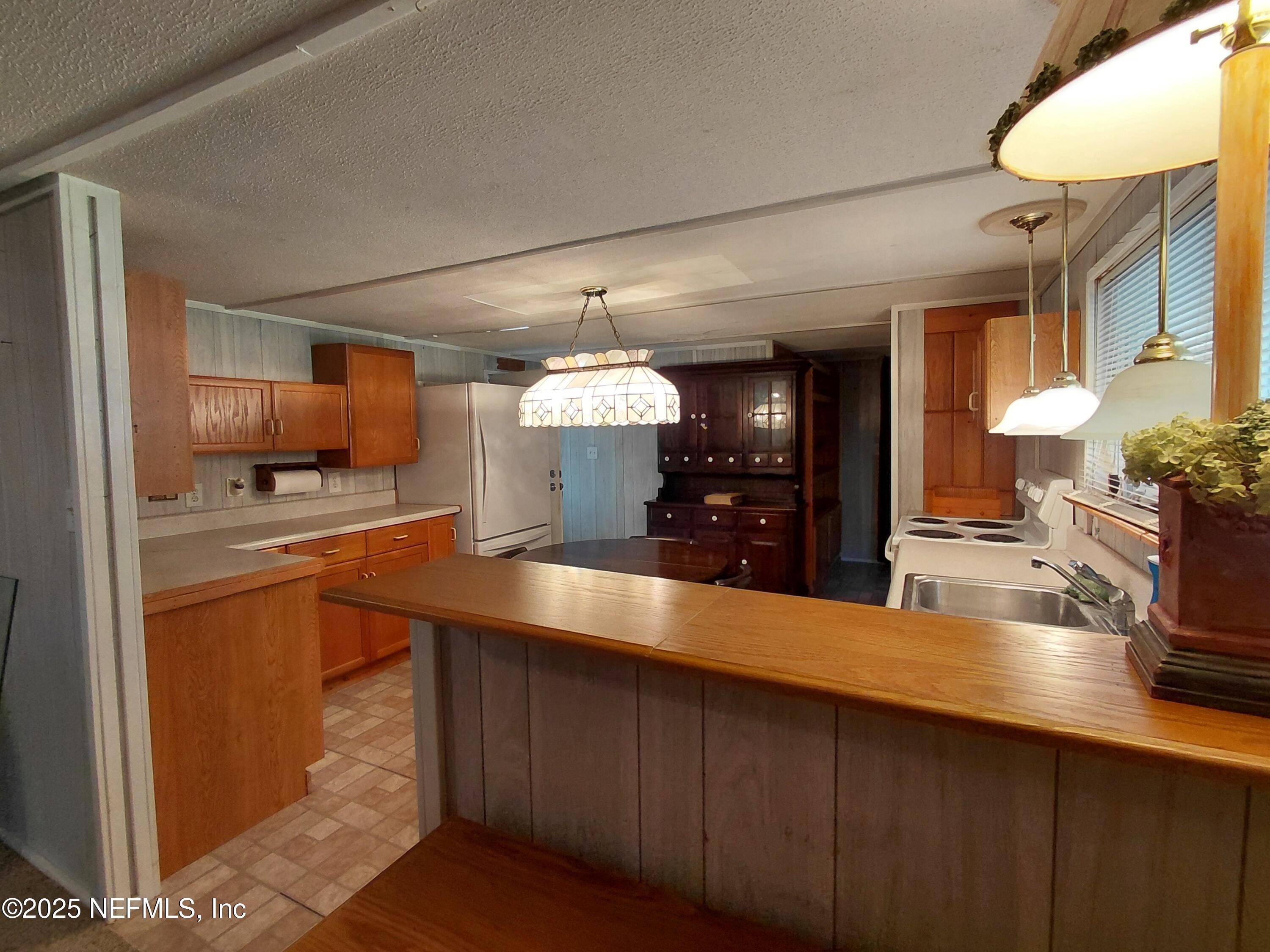 15690 Sears Road Jacksonville, FL 32218 - Photo 8 of 39 a kitchen with stainless steel appliances kitchen island granite countertop a sink counter space and cabinets