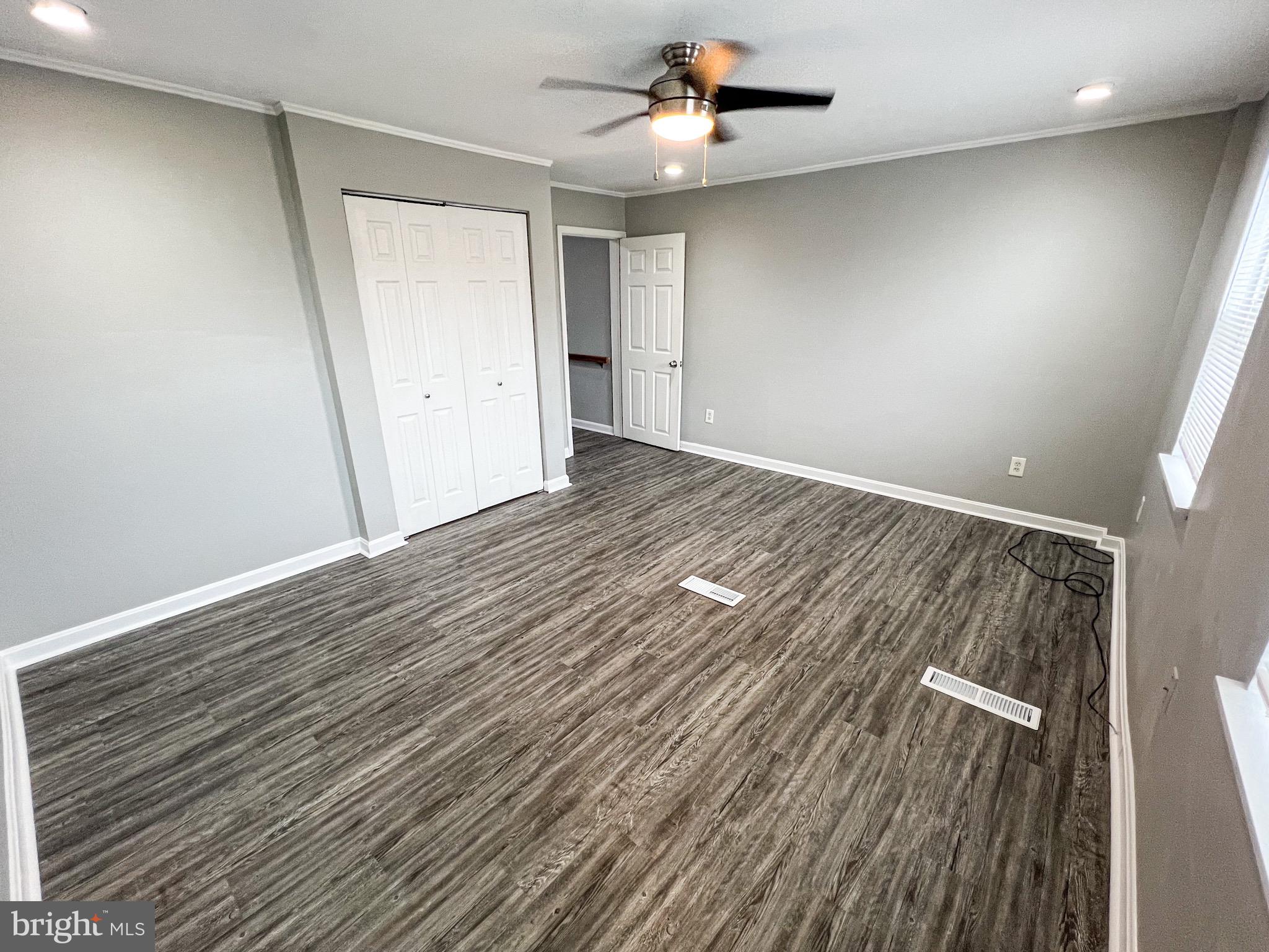 7404 Kirtley Road Baltimore, MD 21222 - Photo 13 of 16 an empty room with wooden floor and windows