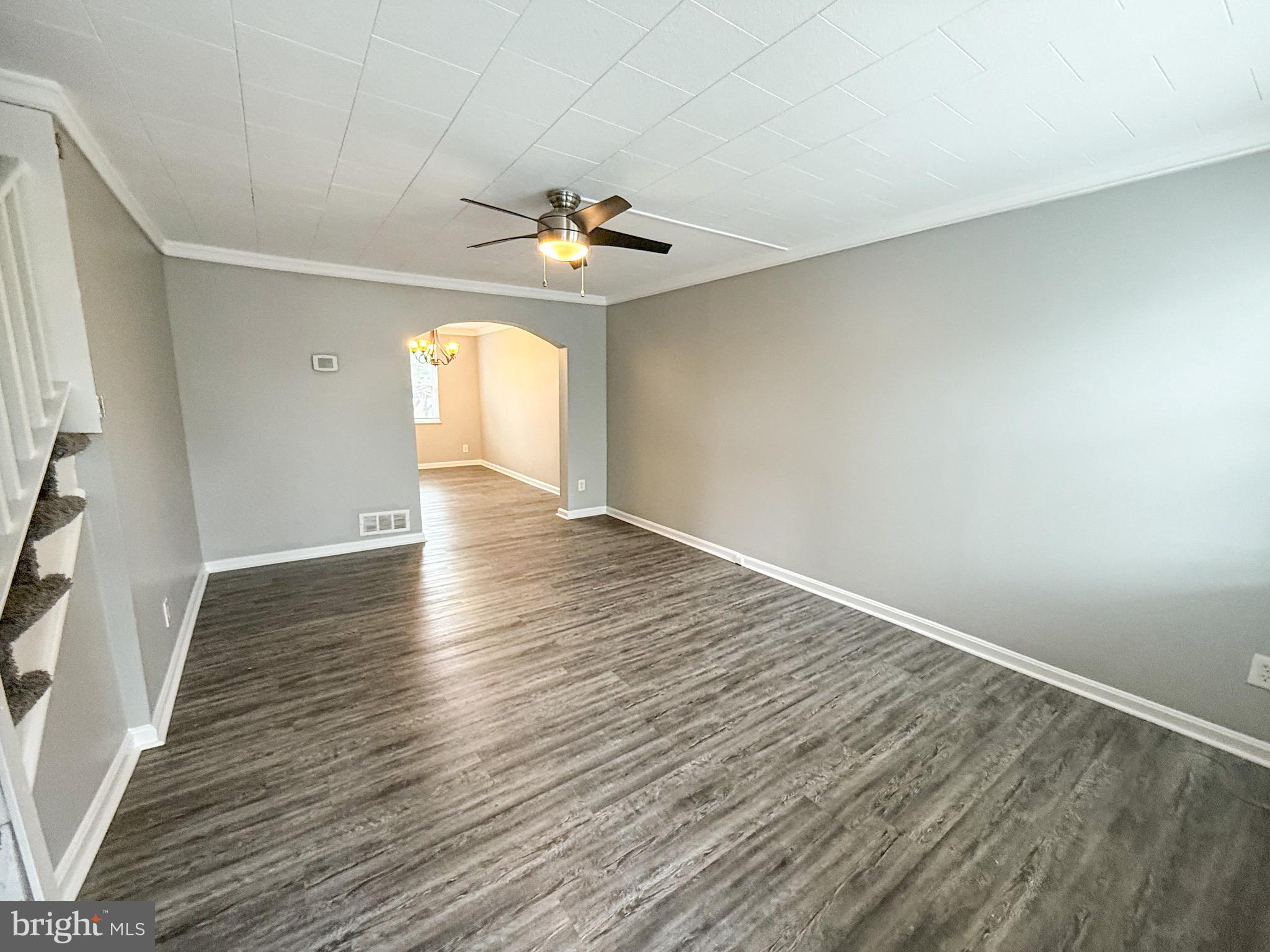 7404 Kirtley Road Baltimore, MD 21222 - Photo 3 of 16 an empty room with wooden floor and chandelier