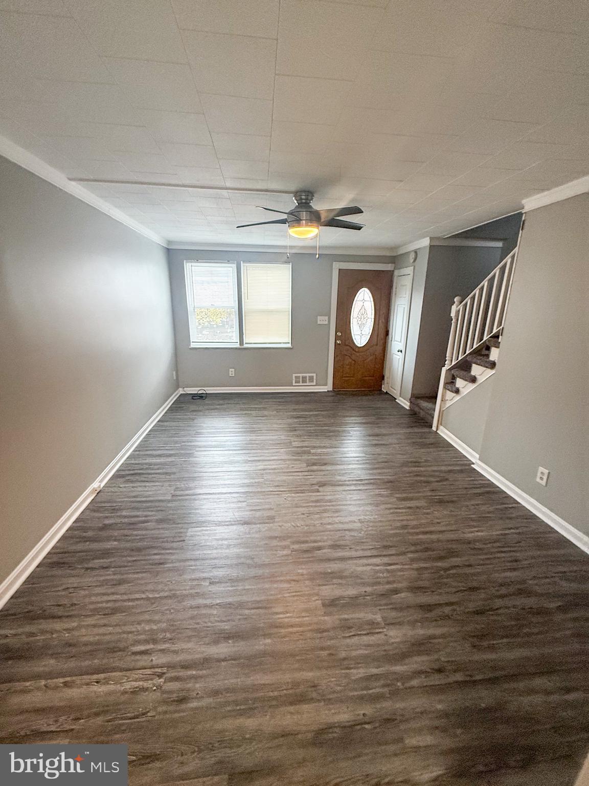 7404 Kirtley Road Baltimore, MD 21222 - Photo 4 of 16 a view of an empty room with window and wooden floor