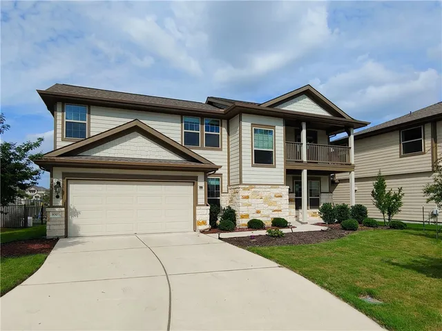 a front view of a house with a yard and garage