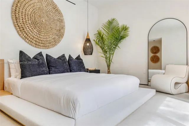 a bedroom with a bed and a potted plant