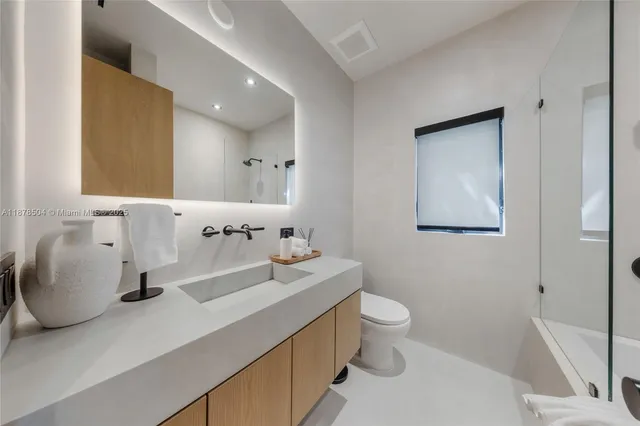 a bathroom with a sink a toilet and mirror