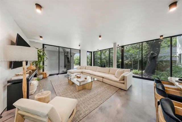 a living room with furniture large windows and a flat screen tv
