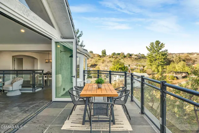 a balcony with table and chairs