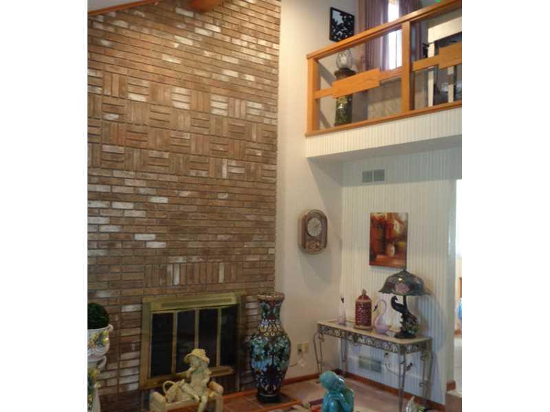 Living Room. Striking Brick Fireplace. Wall-to-wall Carpeting. Opens to Upstairs Loft/Bedroom/Study.