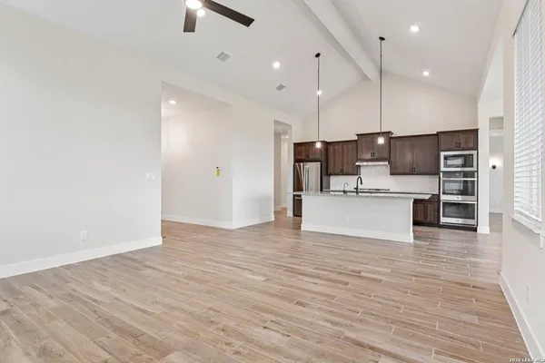 a view of kitchen with kitchen island wooden cabinets and stainless steel appliances