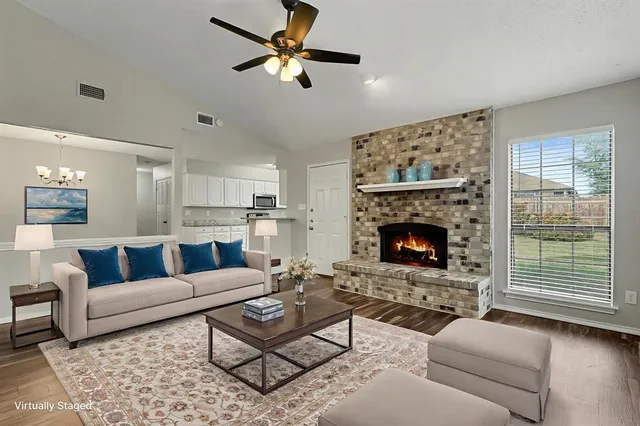 a living room with furniture a fireplace and a large window