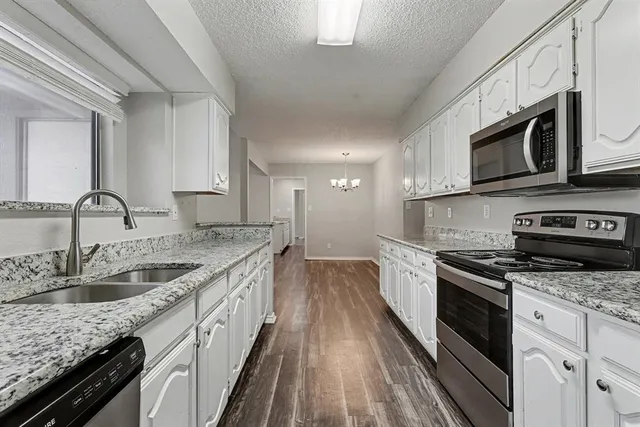 a kitchen with stainless steel appliances granite countertop a sink stove microwave and cabinets
