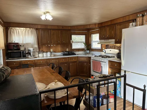 a kitchen with stainless steel appliances granite countertop a stove a sink dishwasher and cabinets with wooden floor