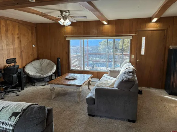 a living room with furniture a chandelier and a large window