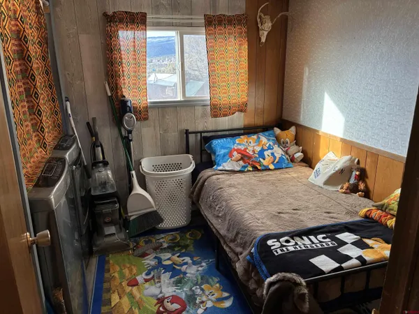 a bedroom with a bed and a dresser next to a window