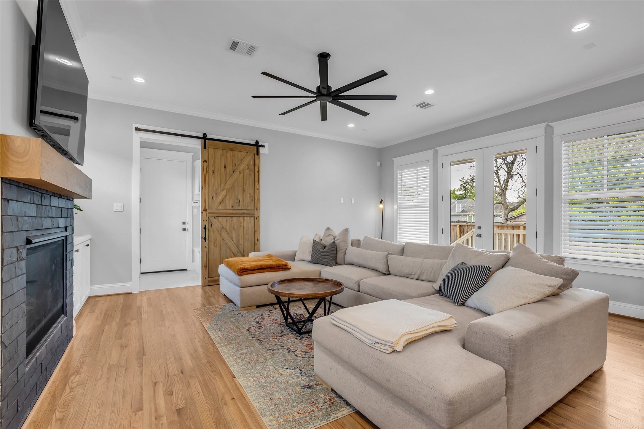 800 Walton Street Houston, TX 77009 - Photo 20 of 38 This view of the living room highlights the glass door leading outside, as well as a door that provides access to the hallway connecting to the garage.
