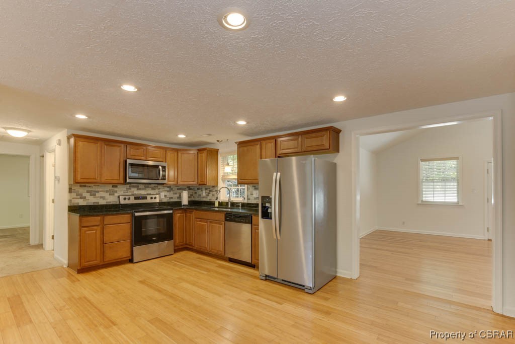 8729 Marlfield Road Gloucester, VA 23061 - Photo 14 of 32 Kitchen with sink, appliances with stainless steel finishes, and light hardwood / wood-style flooring