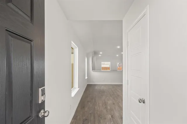 a view of a hallway with wooden floor