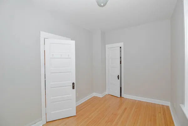 an empty room with wooden floor and closet