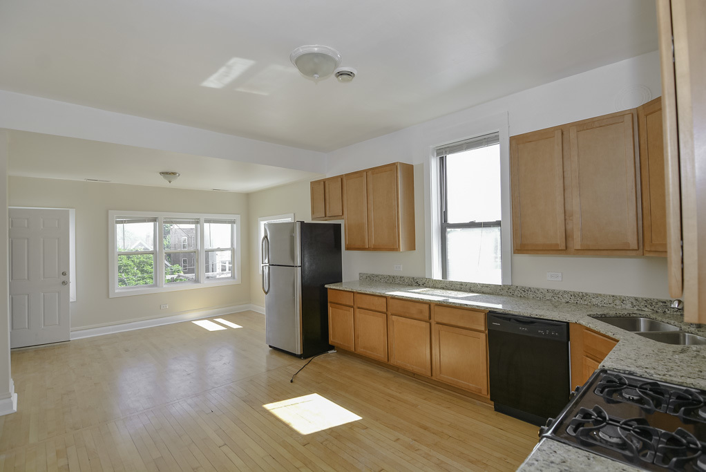 2230 West Iowa Street, Unit 3 Chicago, IL 60622 - Photo 3 of 19 a kitchen with stainless steel appliances granite countertop a refrigerator a sink dishwasher a stove with wooden cabinets and floor