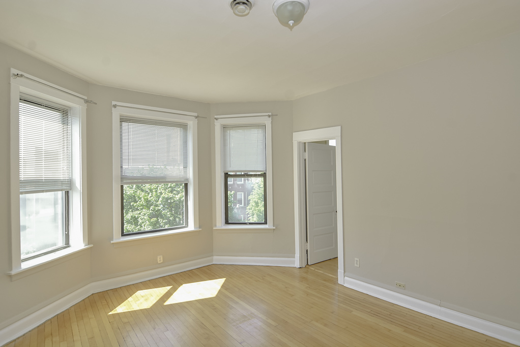 2230 West Iowa Street, Unit 3 Chicago, IL 60622 - Photo 7 of 19 an empty room with wooden floor and windows