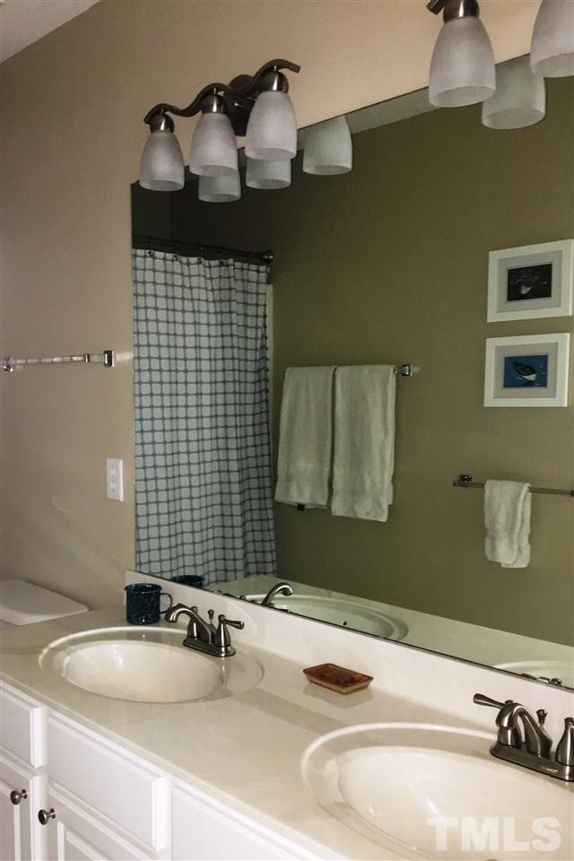 7404 Silver View Lane Raleigh, NC 27613 - Photo 17 of 21 Hall bath with updated light fixtures, dual vanity and tile floor.