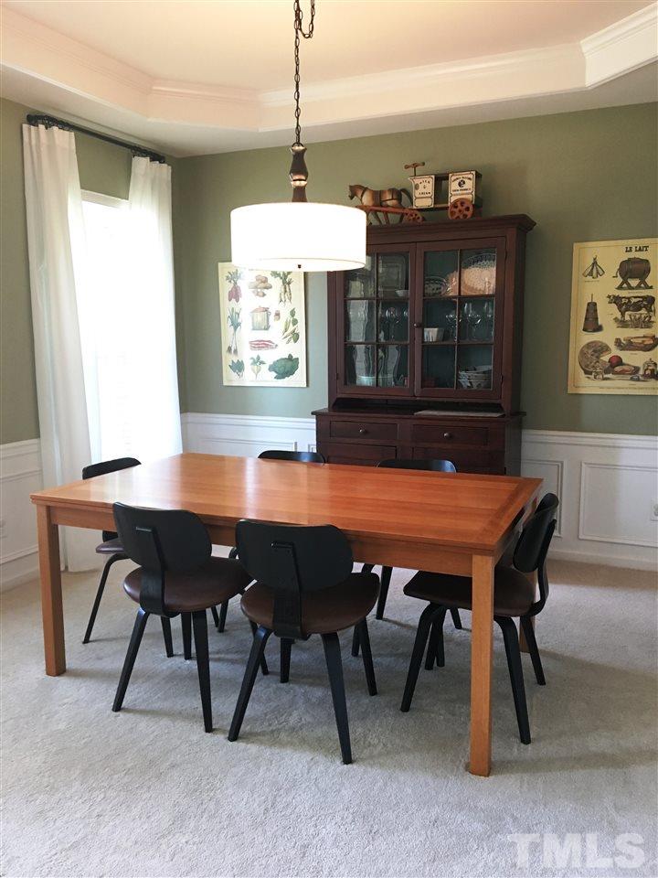 7404 Silver View Lane Raleigh, NC 27613 - Photo 2 of 21 Elegant separate dining room, just off the kitchen, features trey ceiling, wainscoting and stylish drum pendant light.