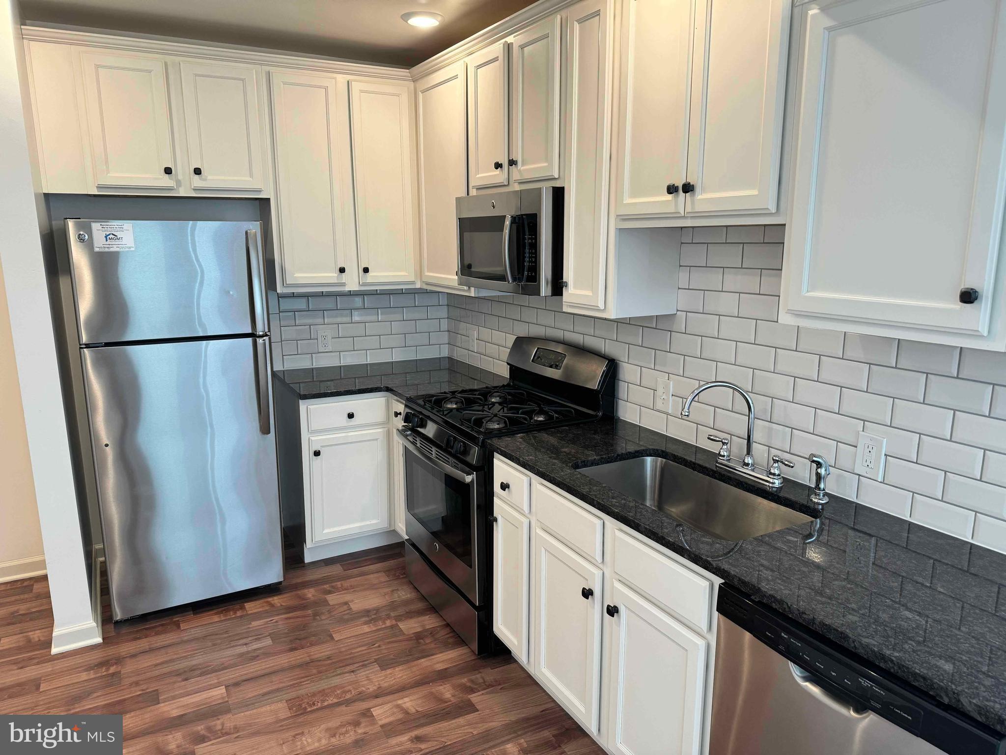 5261 Ridge Avenue, Unit 206 Philadelphia, PA 19128 - Photo 1 of 10 a kitchen with granite countertop white cabinets and stainless steel appliances