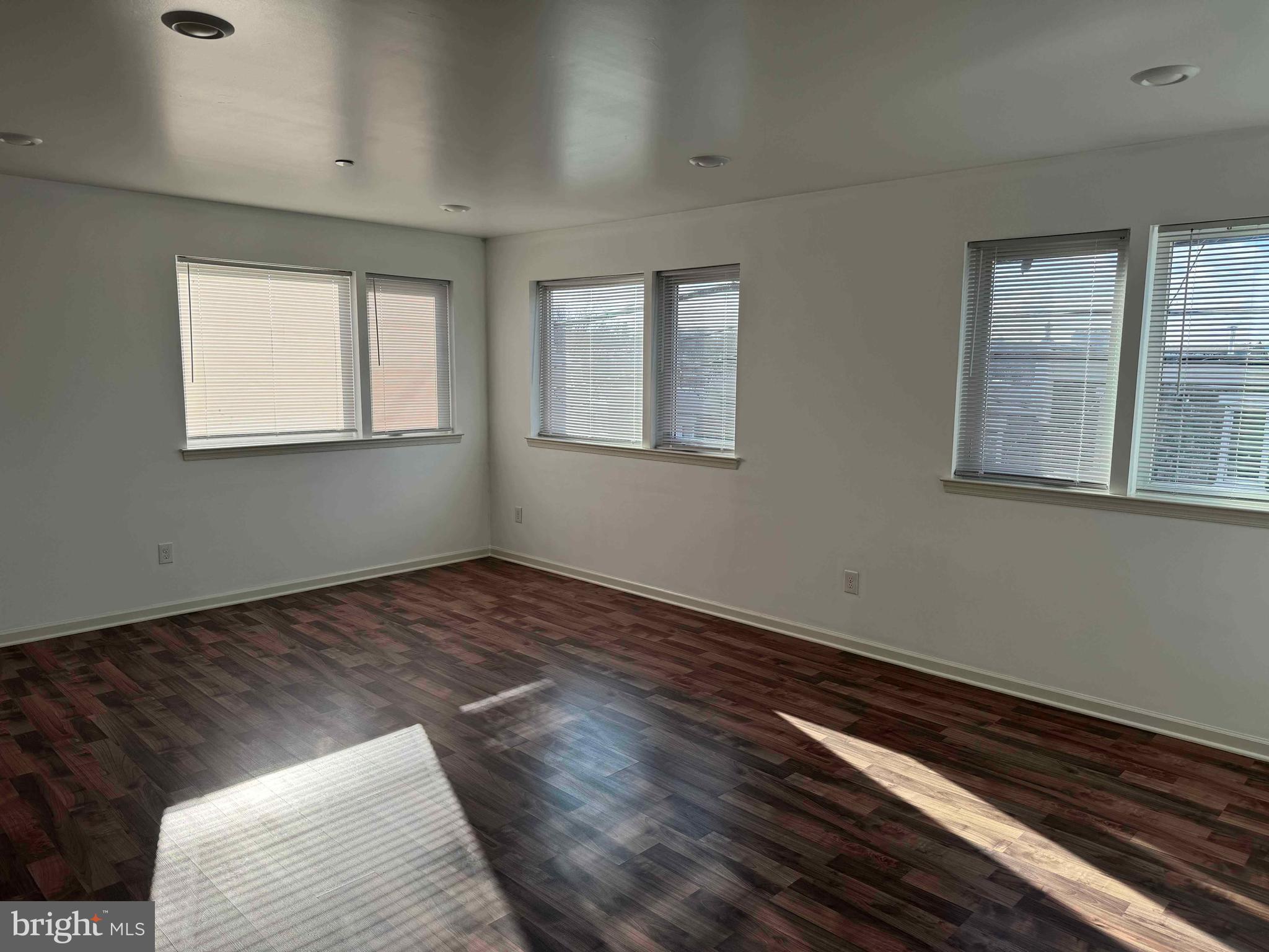 5261 Ridge Avenue, Unit 206 Philadelphia, PA 19128 - Photo 4 of 10 a view of an empty room with wooden floor and a window
