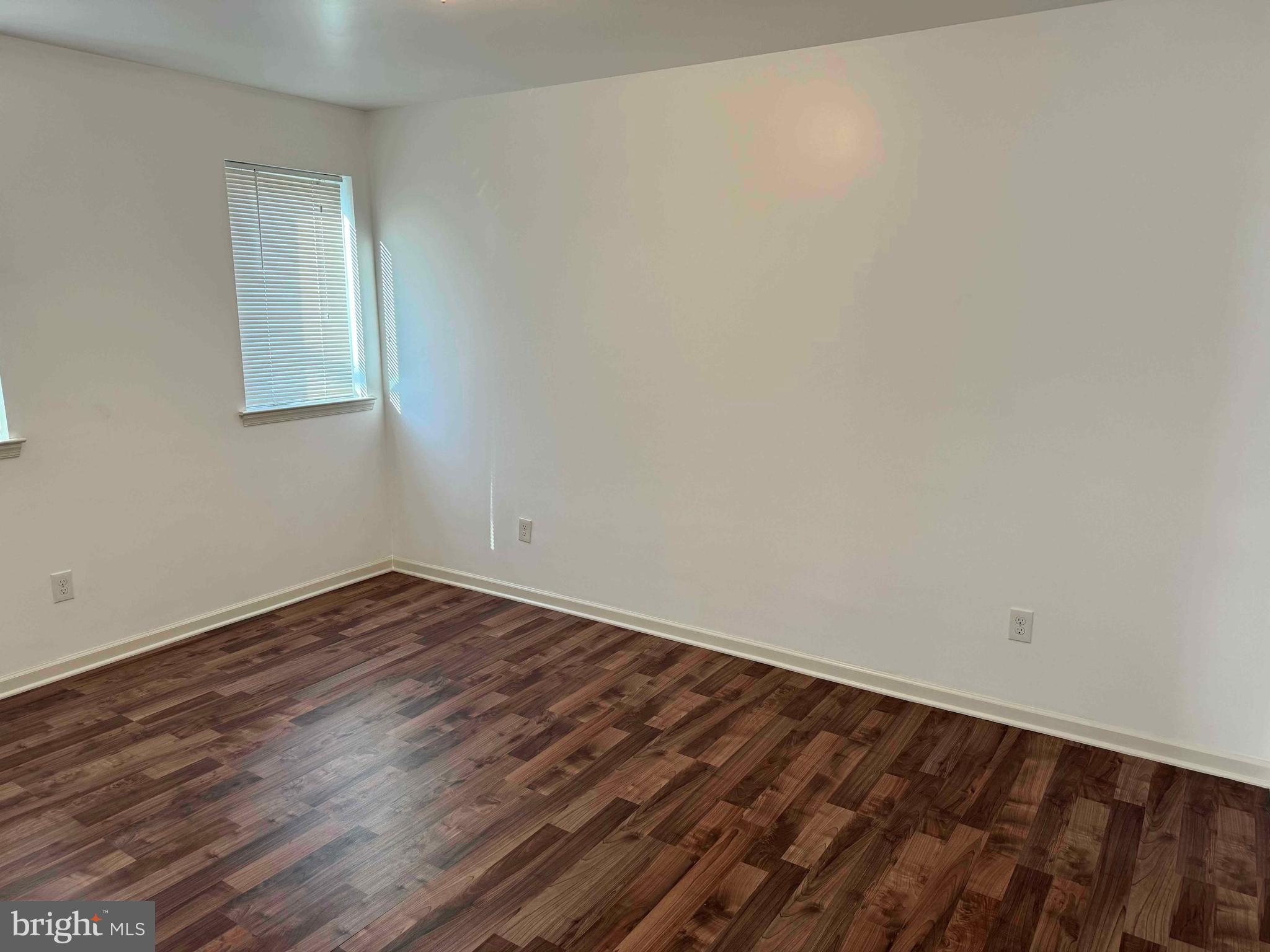 5261 Ridge Avenue, Unit 206 Philadelphia, PA 19128 - Photo 6 of 10 a view of an empty room with wooden floor and a window