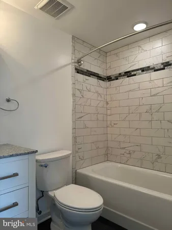 a bathroom with a shower a toilet and a bathtub