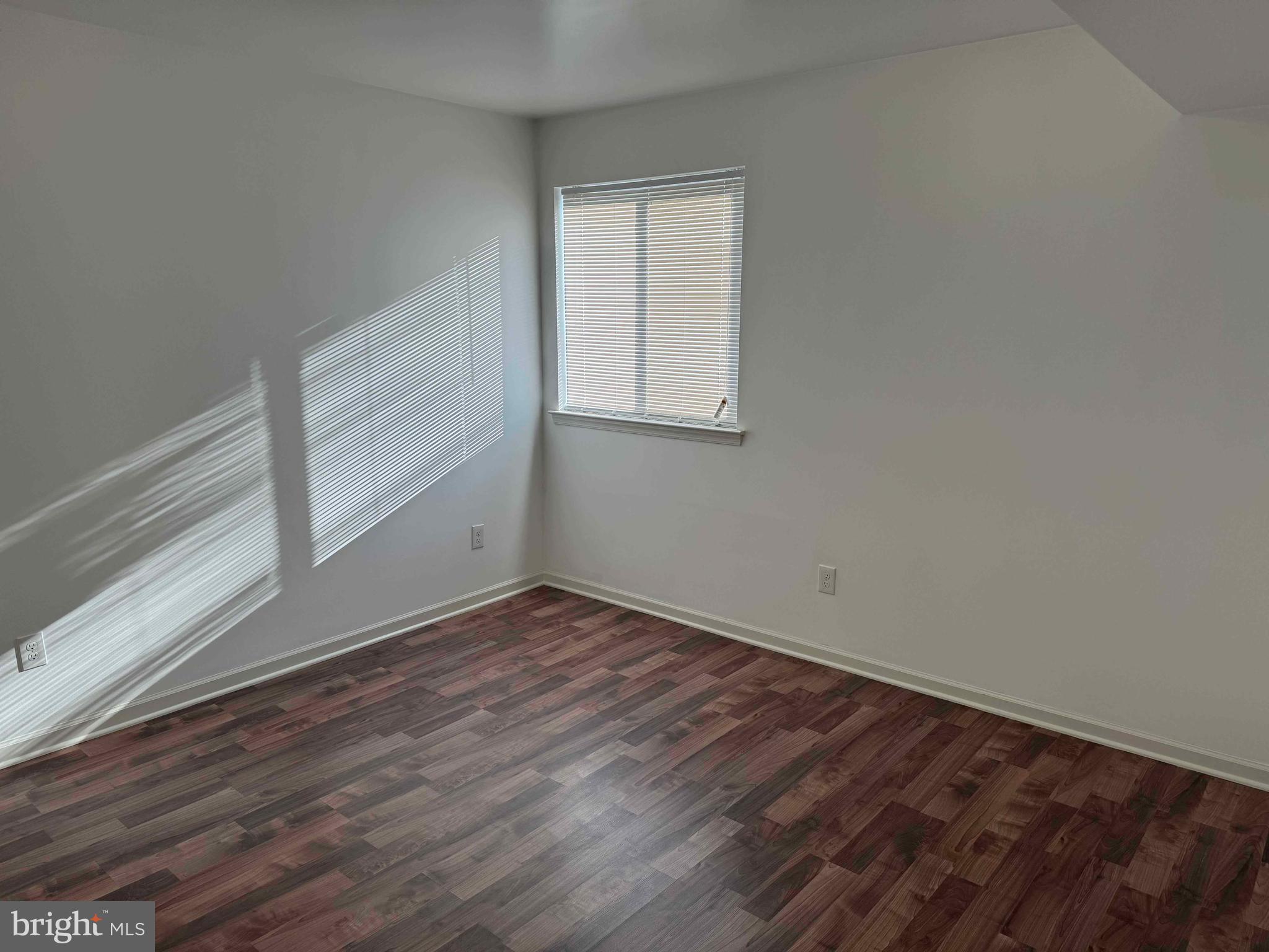5261 Ridge Avenue, Unit 206 Philadelphia, PA 19128 - Photo 9 of 10 a view of an empty room with wooden floor and a window