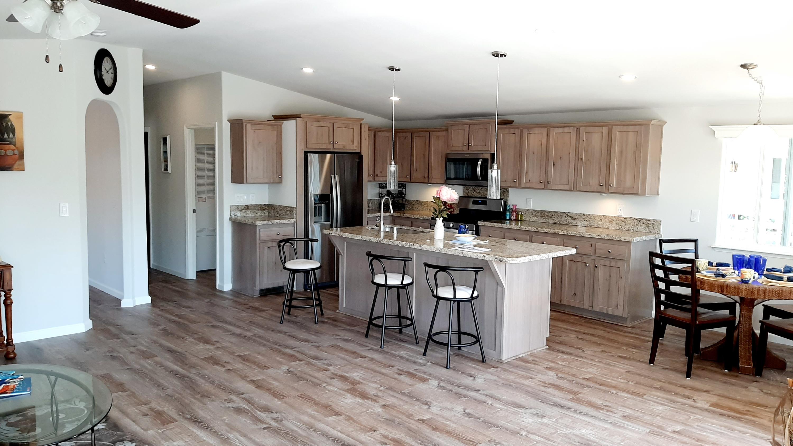 340 Old Mill Road, Unit 18 Santa Barbara, CA 93110 - Photo 4 of 22 a kitchen with stainless steel appliances a refrigerator a stove a sink dishwasher and a dining table with wooden floor