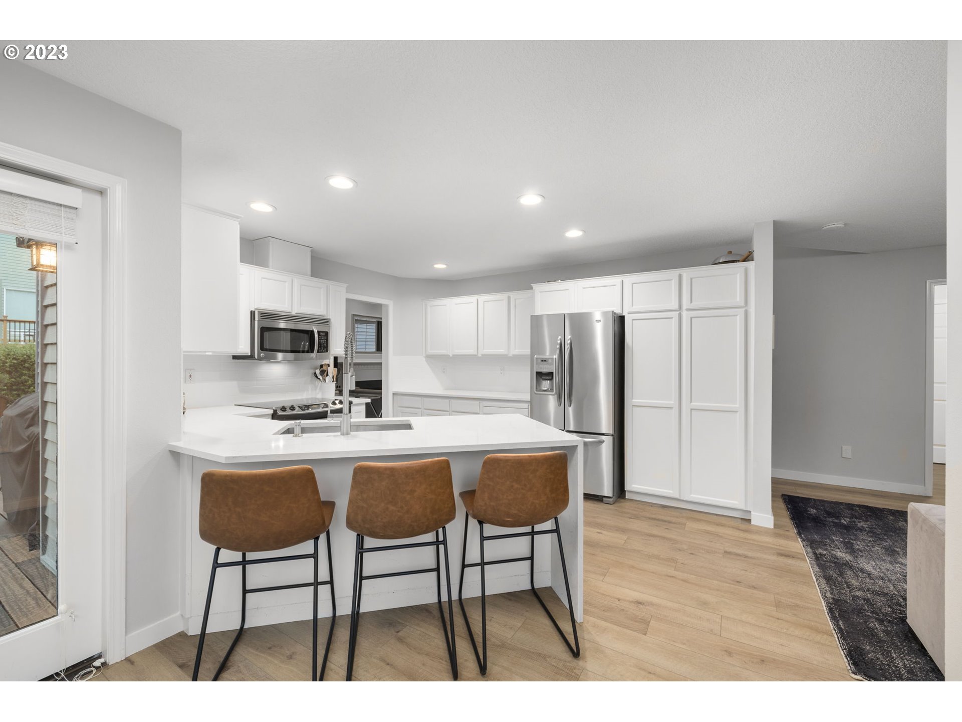 4806 Southwest Orchard Lane Portland, OR 97219 - Photo 12 of 35 a kitchen with stainless steel appliances a table and chairs