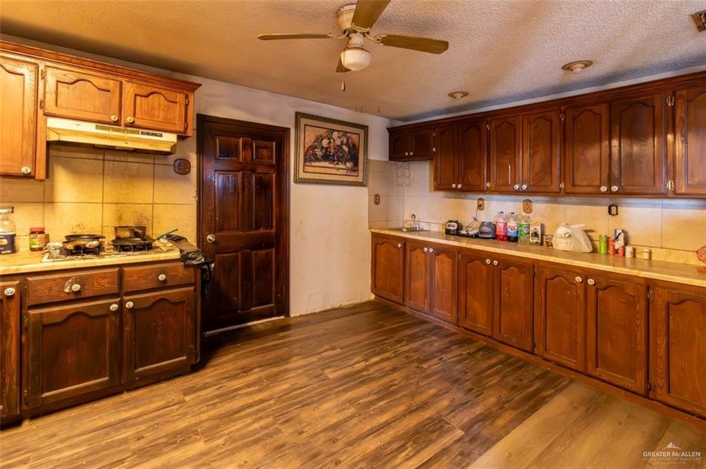 733 East Earling Road San Juan, TX 78589 - Photo 12 of 19 a kitchen with stainless steel appliances granite countertop a sink cabinets and wooden floor