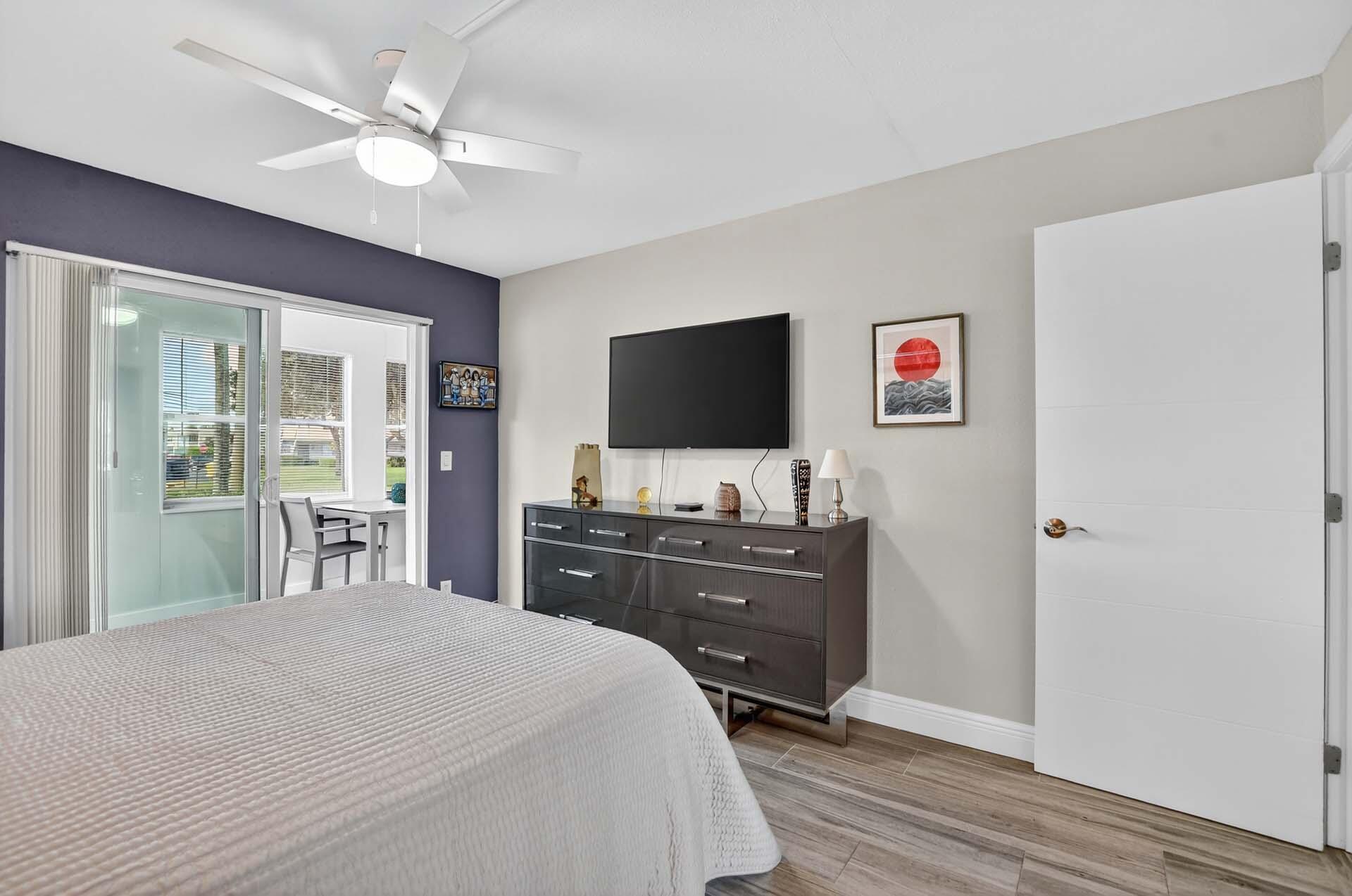 360 Flanders Drive, Unit H Delray Beach, FL 33484 - Photo 15 of 65 a bedroom with a bed and a flat screen tv